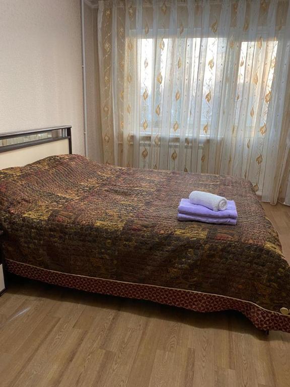 卡拉甘达Домашний уют的一间卧室配有一张床,上面有两条毛巾