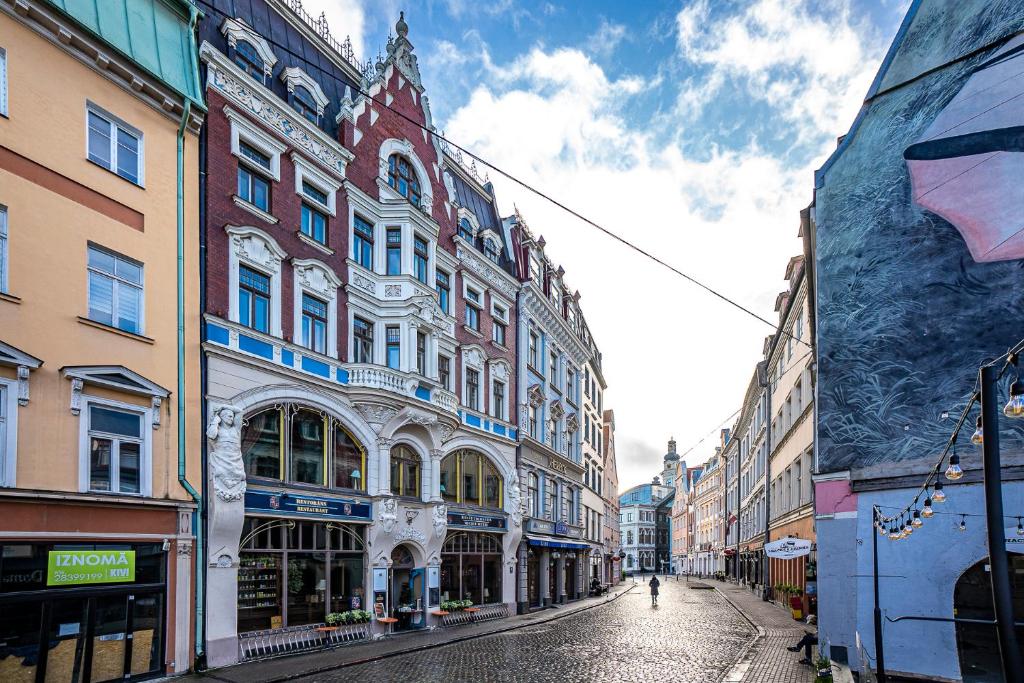 里加Blue Bird Hostel in Riga Old Town的街道上,有建筑的人和沿着街道走的人