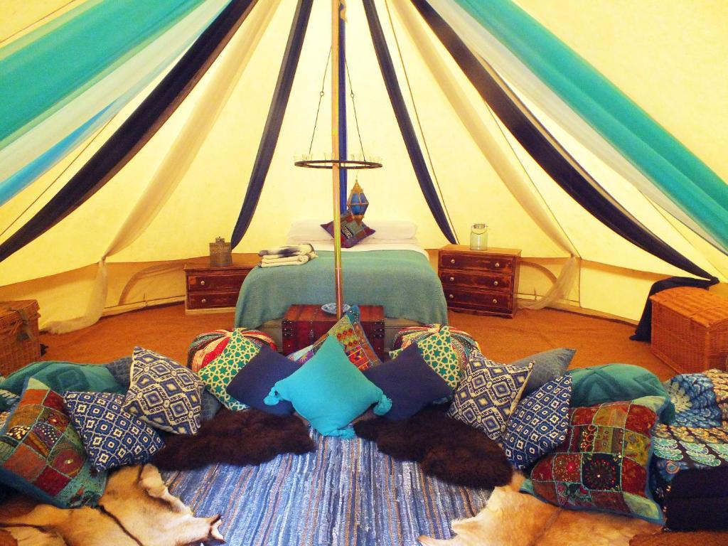 纽伯里Hollington Park Glamping的帐篷,配有狗,躺在带枕头的沙发上