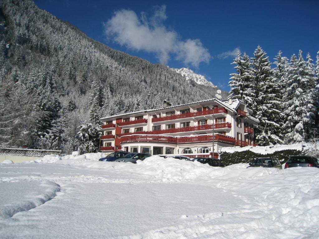 夏蒙尼-勃朗峰Chalet Hôtel La Sapinière的山前大雪中的一座大建筑