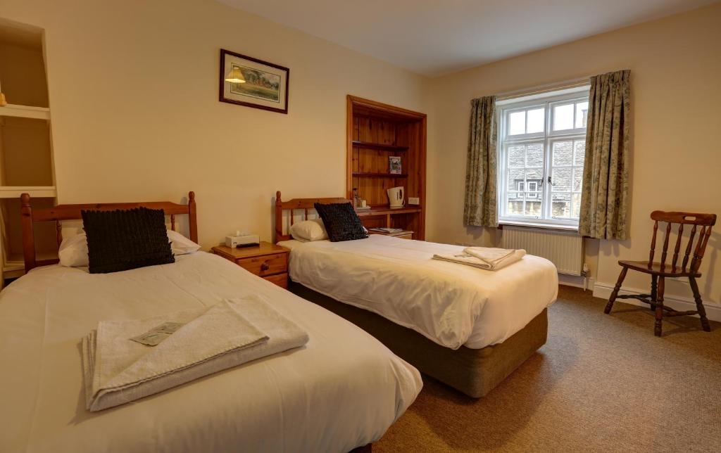 奇平卡姆登志愿者旅馆的酒店客房设有两张床和窗户。