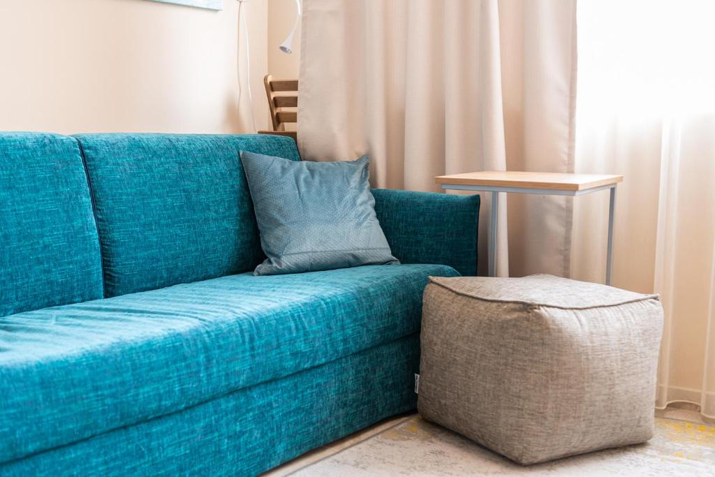 帕莫瑞Aquamarine的一张蓝色的沙发,上面有枕头,放在一个房间里