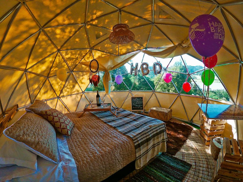 苏埃斯卡Alma de Campo Glamping - Laguna de Suesca的蒙古包内一间卧室,配有一张床和气球
