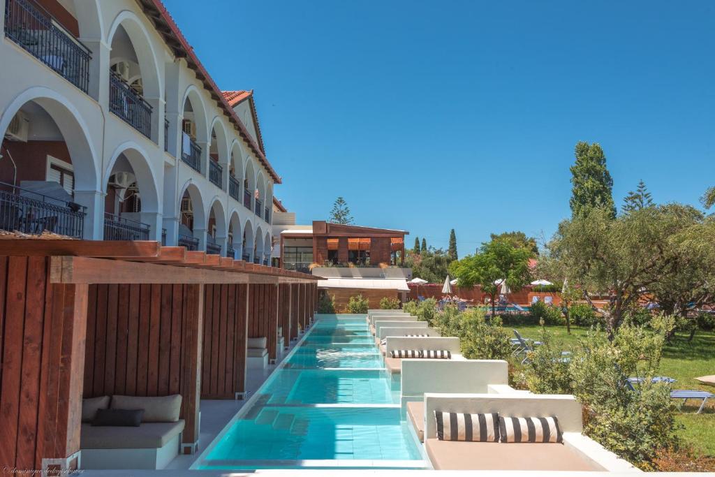 拉加纳斯Castelli Hotel-Adults Only的一座酒店,在一座建筑旁边设有游泳池