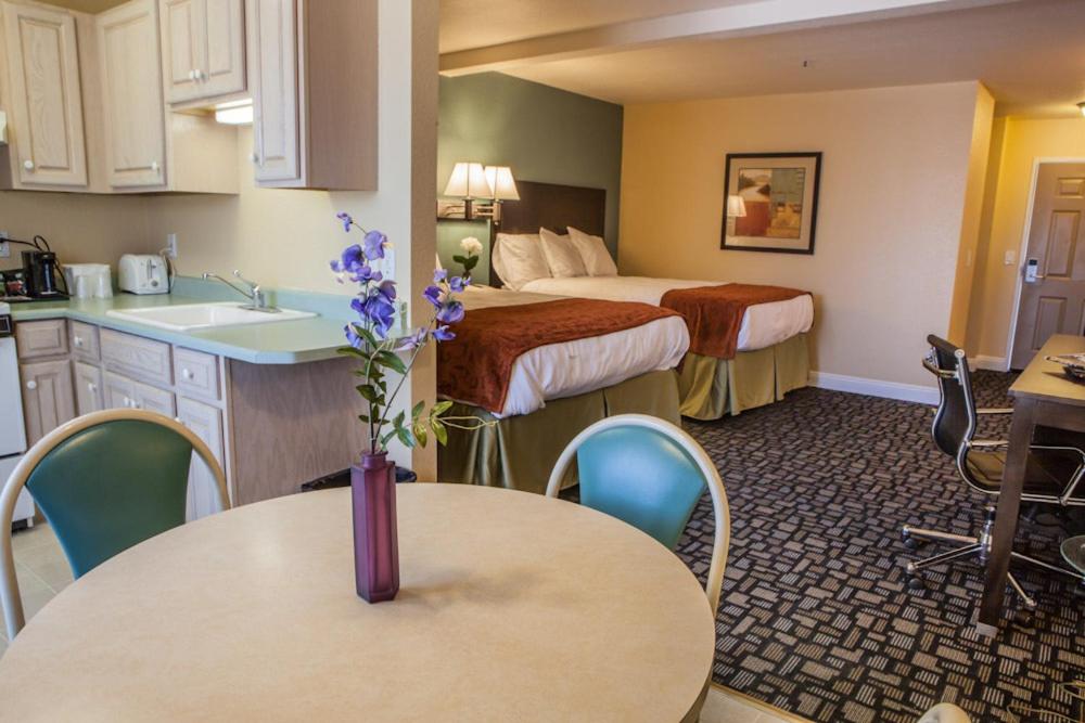 诺瓦托马琳伍德套房酒店的酒店客房设有两张床、一张桌子和厨房