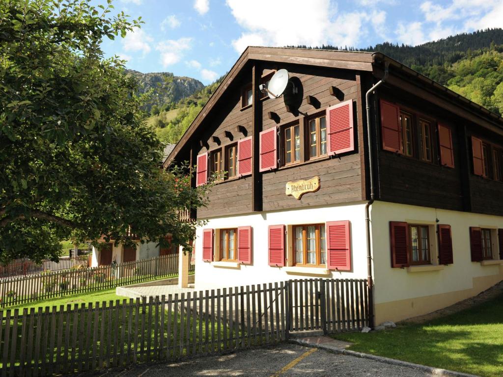 布拉腾holiday home in Blatten with private terrace的一座带红色百叶窗和围栏的房子
