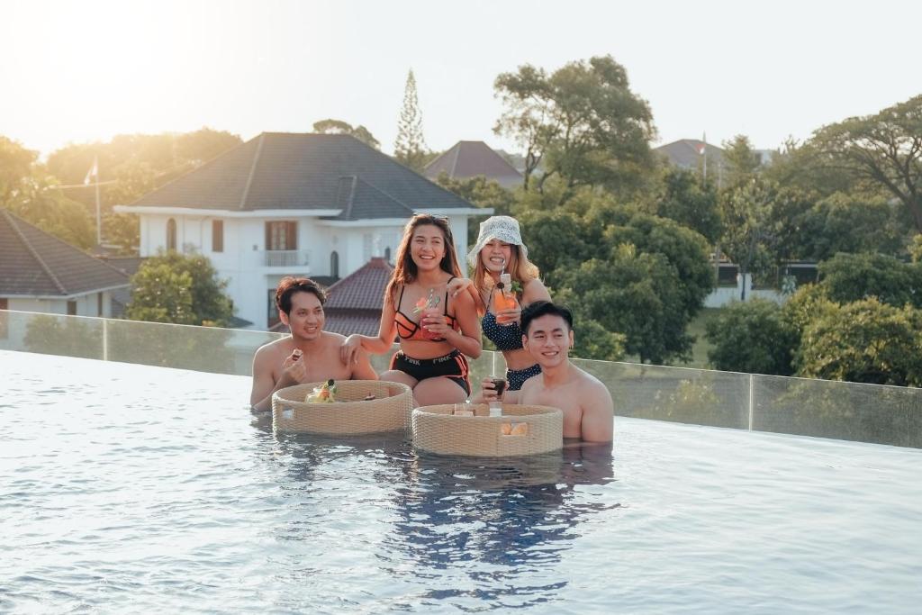 三宝垄三宝垄魏玛丽翁酒店的一群人坐在游泳池里