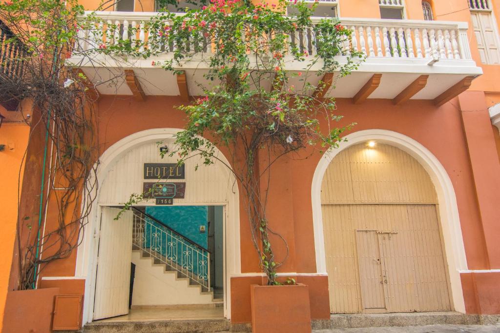 卡塔赫纳Hotel Marie Real Cartagena的一座橘色的建筑,门前有一棵树