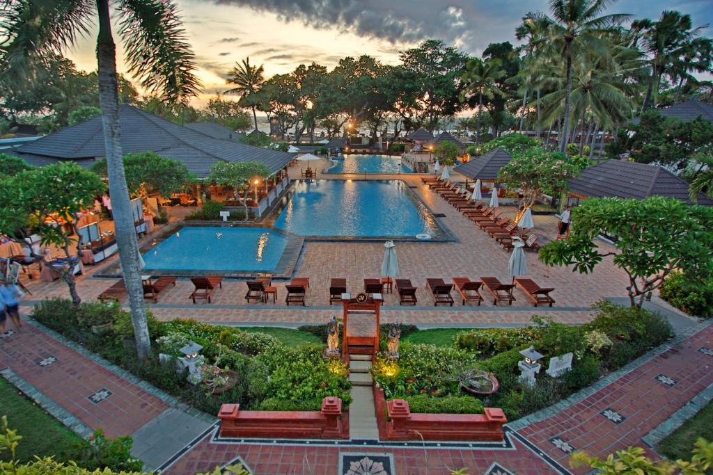 勒吉安The Jayakarta Bali Beach Resort的度假村设有2个带桌椅的游泳池