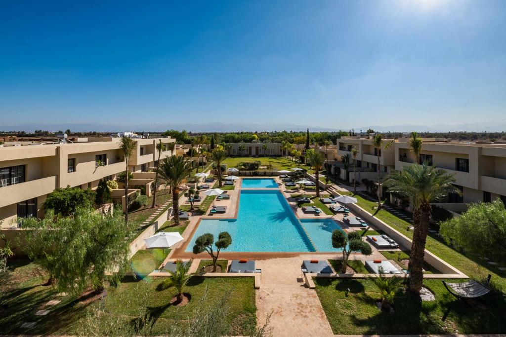 马拉喀什希洛岩精品酒店及马拉喀什Spa的享有棕榈树和建筑的游泳池的顶部景致