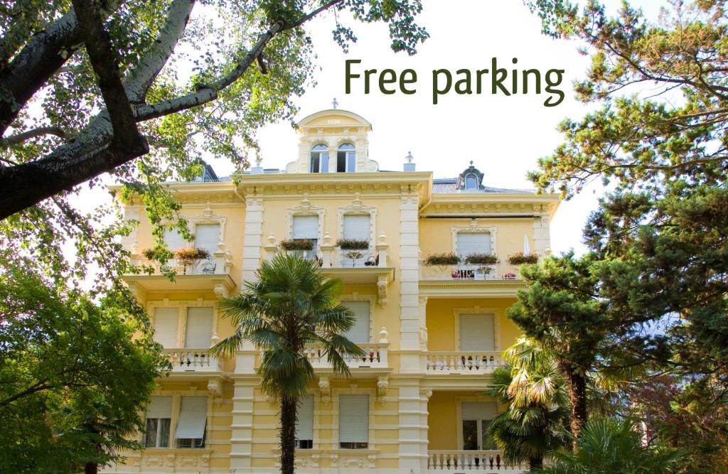 梅拉诺Hotel Villa Westend的黄色的建筑,字眼上是免费停车场