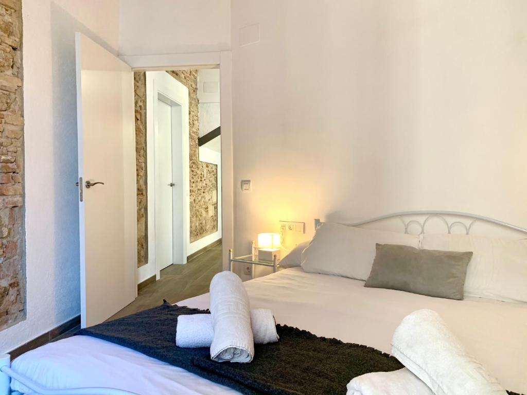 巴达洛纳Vila Badalona的卧室配有白色床和毛巾
