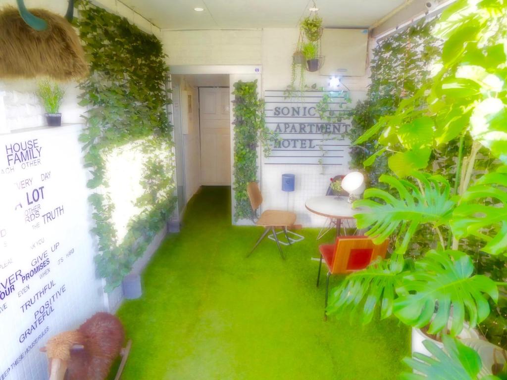 太宰府市SONIC APARTMENT HOTEL的一间绿草客房,配有桌椅
