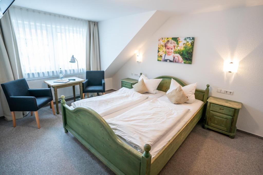 兰格瑙Hotel-Gasthof zur Linde的一间卧室配有一张大床和两把椅子
