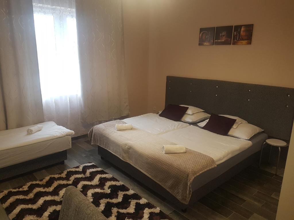 塞格德Napfény Szállás的一间卧室设有一张大床和一个窗户。