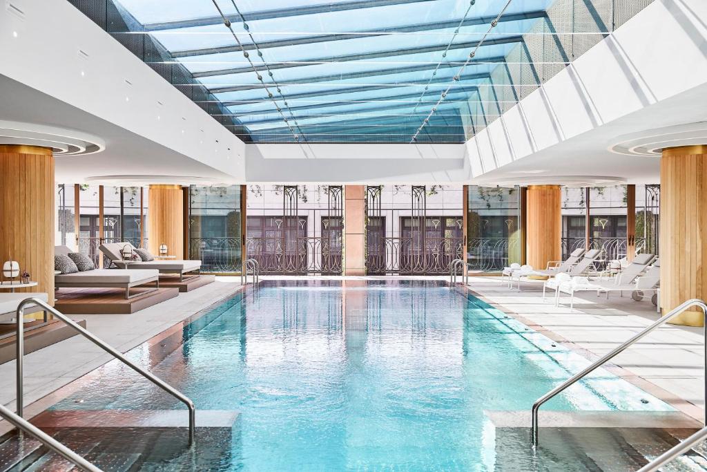 马德里Four Seasons Hotel Madrid的一个带玻璃天花板的大型游泳池