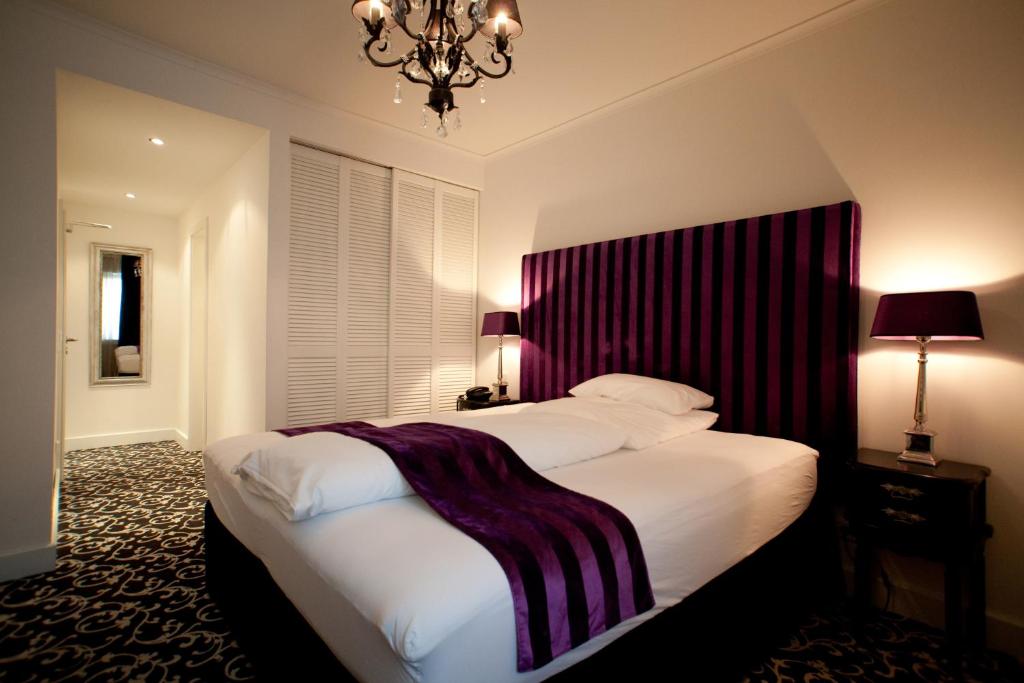 杜塞尔多夫亚历山大酒店的一间卧室配有一张大床和一个吊灯。