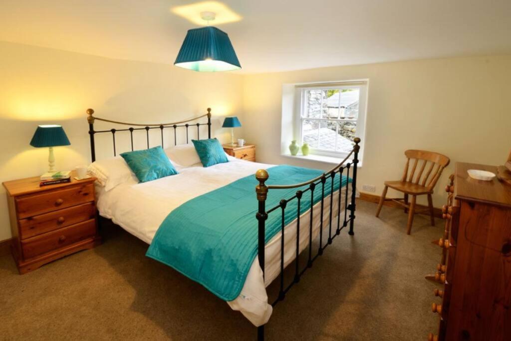 格拉斯米尔Stickle Cottage, Great Langdale的一间卧室设有一张大床和一个窗户。