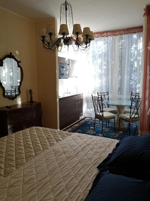 罗马AKIRE的一间卧室配有一张床和一张桌子及椅子