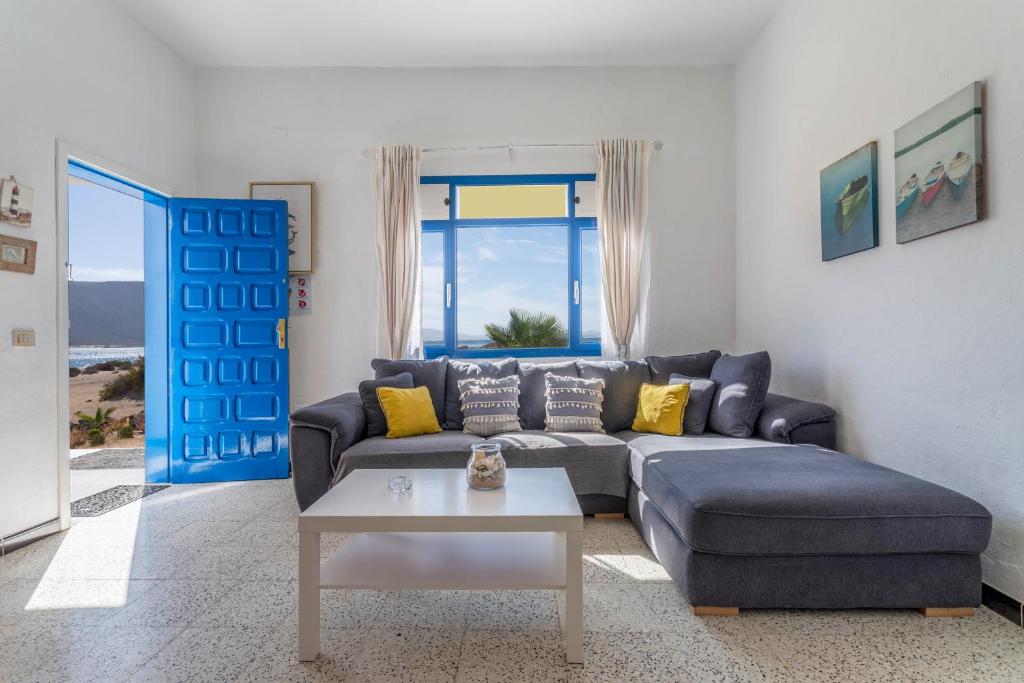 塞博河畔卡莱塔El Graciosero的客厅配有蓝色的沙发和桌子