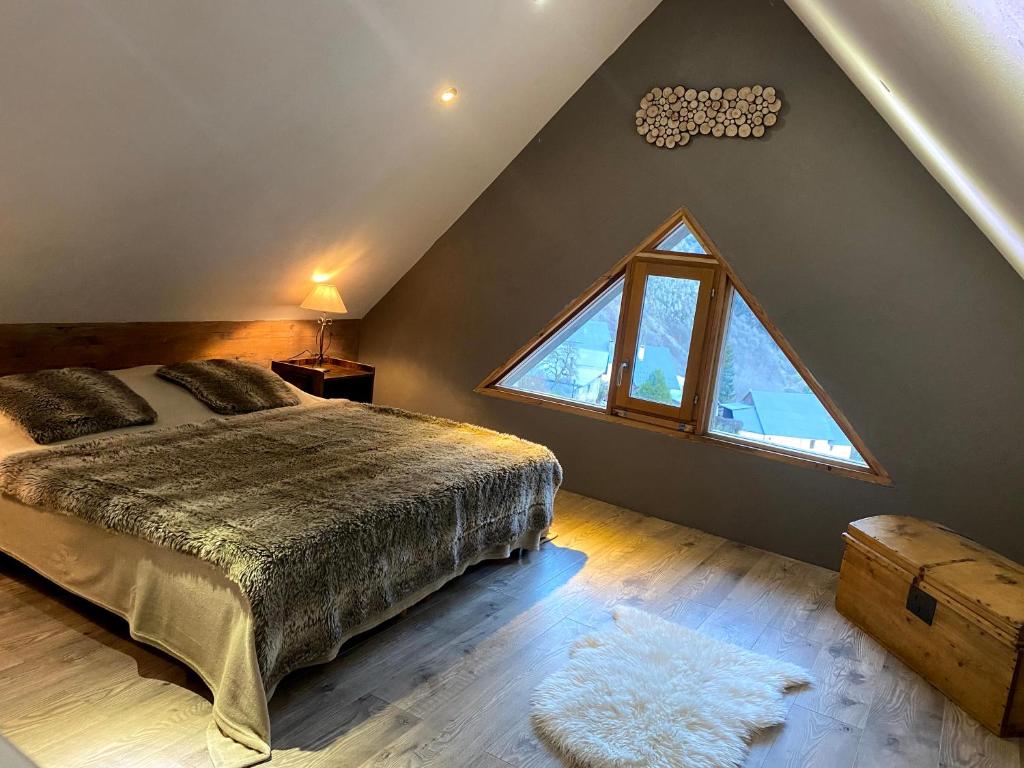 莱德萨阿尔卑斯VENOSC Le Haut de la Grange的一间卧室设有一张床和一个大窗户