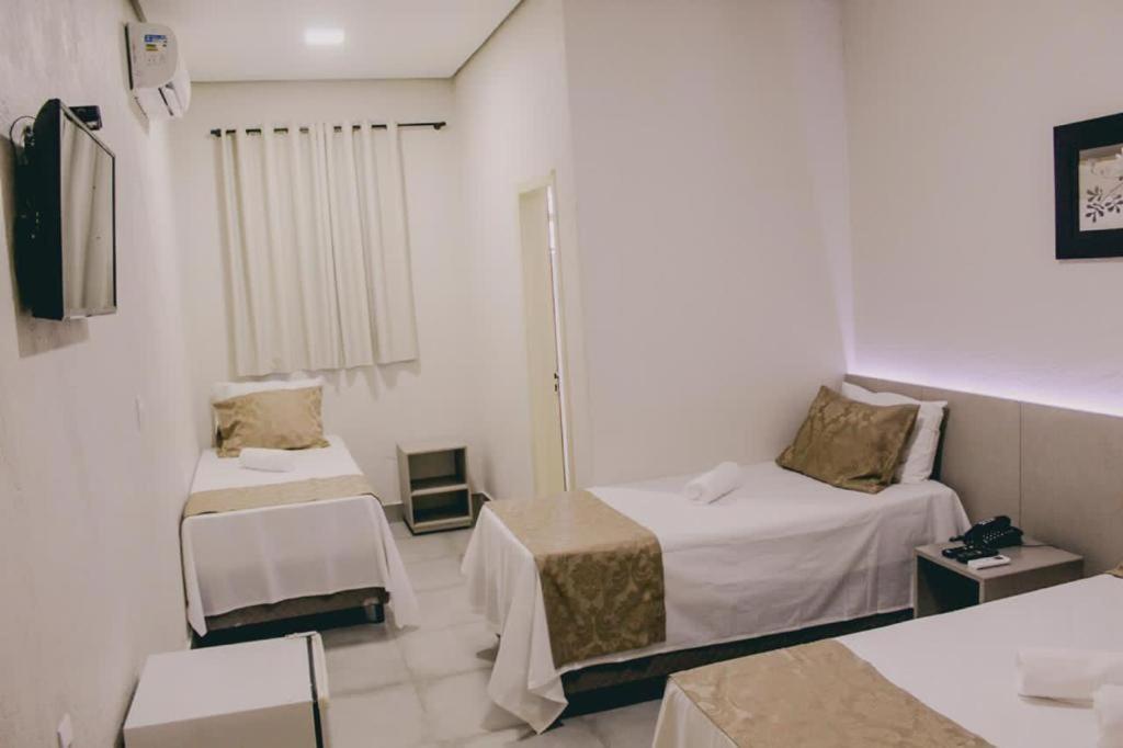 萨利纳斯Hotel Valley Hills的小房间设有两张床和电视