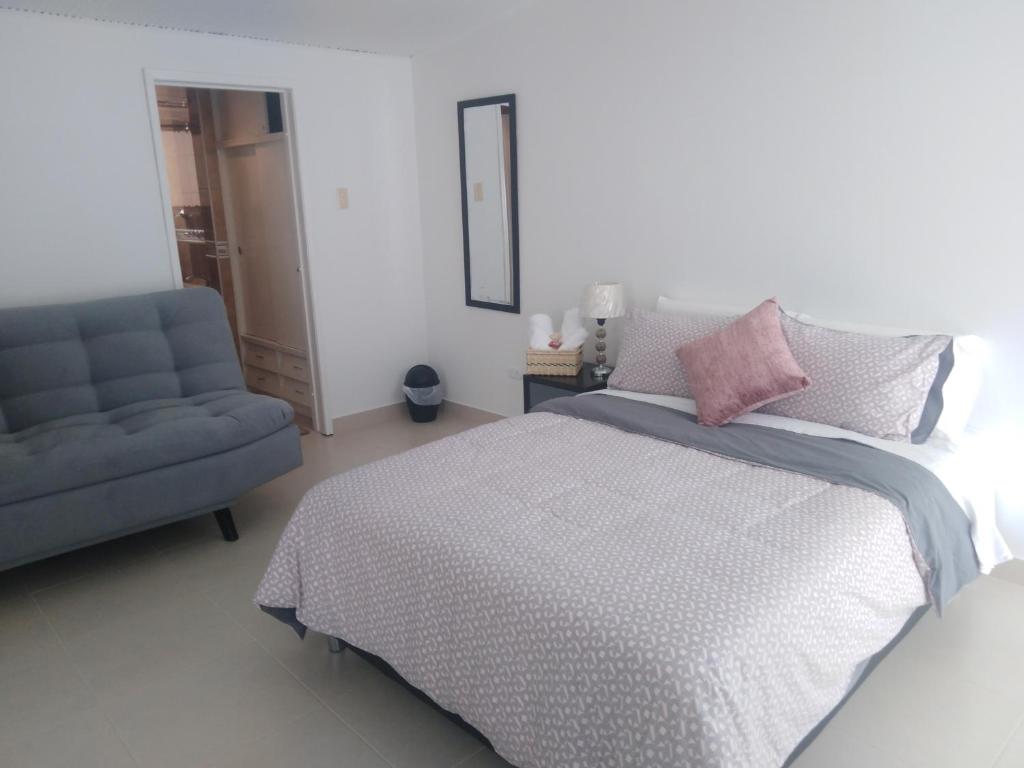 波哥大Casa Coffice的一间卧室配有一张床和一张蓝色椅子