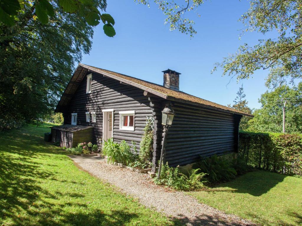 弗朗科尔尚Open wooden chalet built against a hill的田野中的一座老房子,有一条通往房子的道路