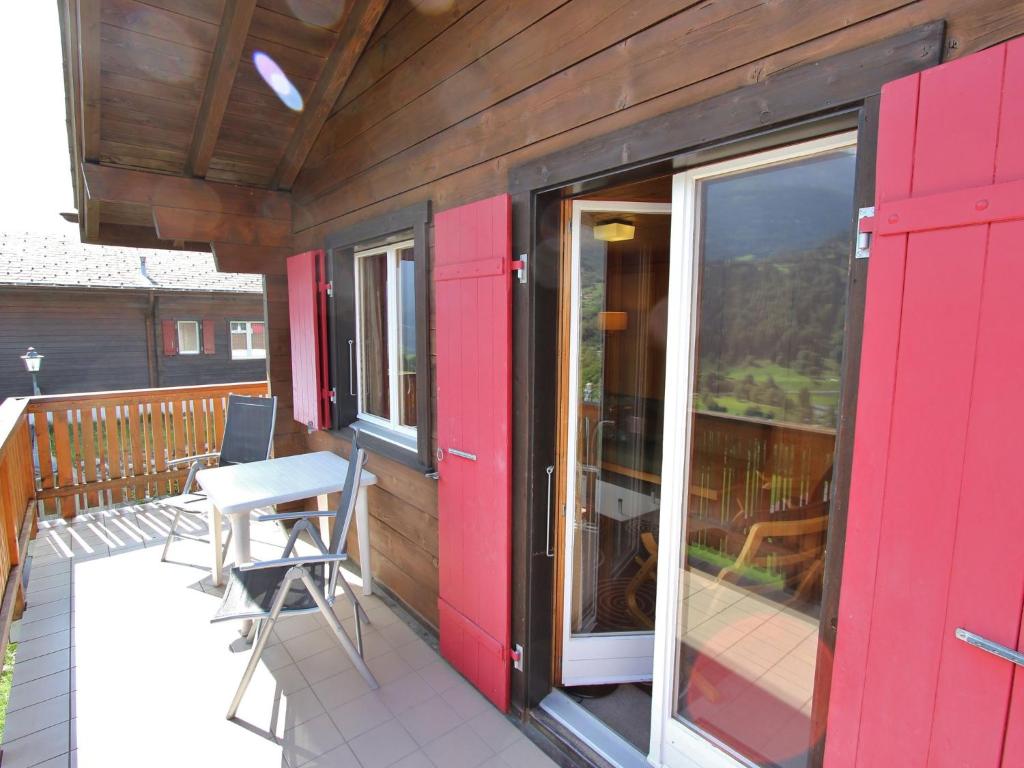 菲施Attractive chalet in Fiesch Wiler with views的一个带红色门和桌椅的甲板