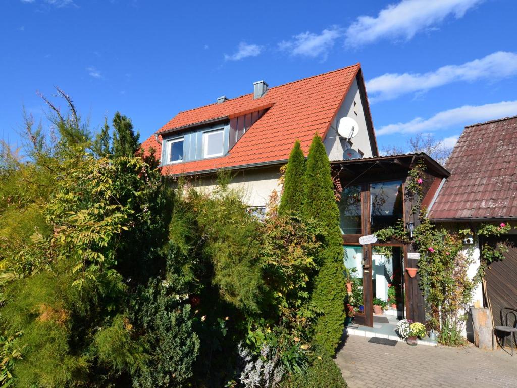 KunreuthApartment in the middle of Franconian Switzerland的一座有红色屋顶和一些树木的房子