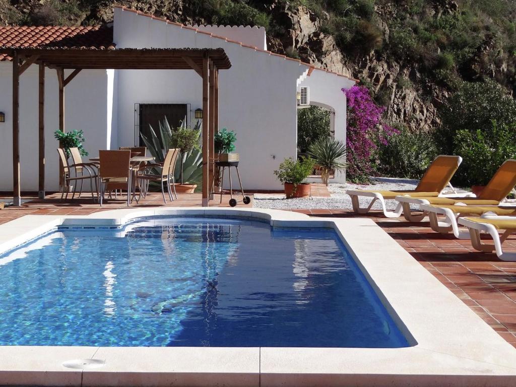 阿里纳斯Belvilla by OYO Casa Martijo的一个带椅子的游泳池以及一座房子