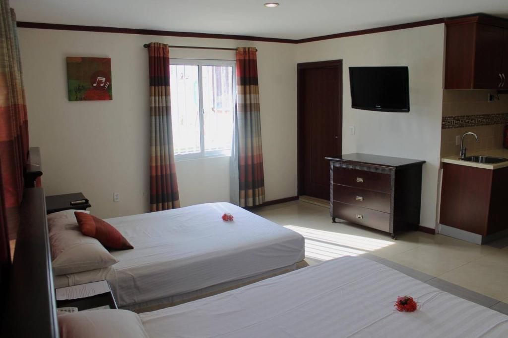 威廉斯塔德Curacao Suites Hotel的酒店客房设有两张床和电视。