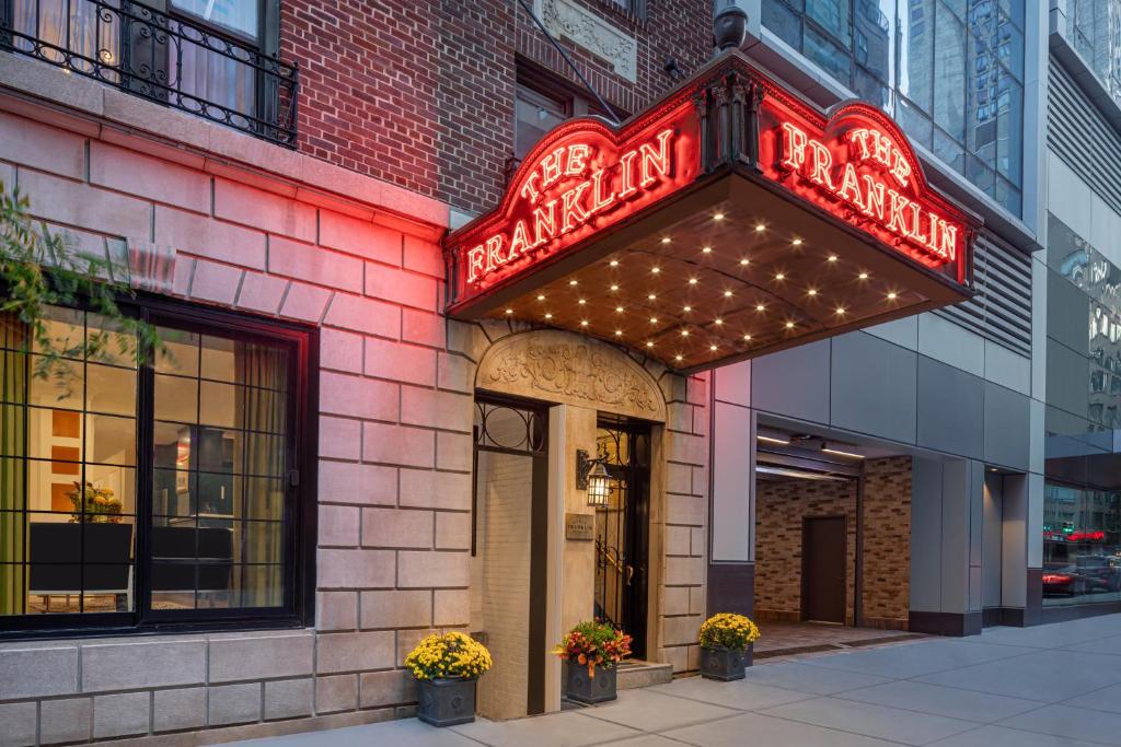 纽约voco The Franklin New York, an IHG Hotel的大楼一侧有 ⁇ 虹灯标志的餐厅