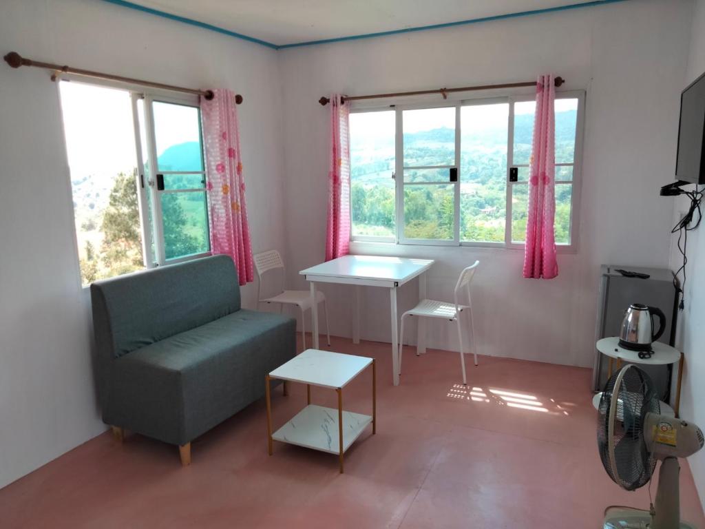 Ban Khao Ya Nua江哈瓦特卡奥户度假村的客厅配有椅子、桌子和窗户
