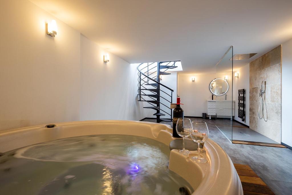 波尔多Mieuxqualhotel jacuzzi privatif Le rond的浴室配有带酒杯的浴缸