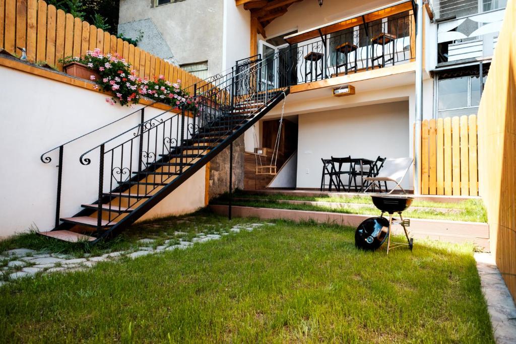 大特尔诺沃Tarno Guest House的庭院里设有楼梯和烧烤架的房子