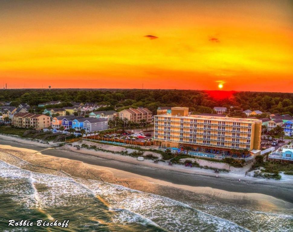 默特尔比奇Holiday Inn Resort Oceanfront at Surfside Beach, an IHG Hotel的日落时分海滩上度假村的空中景致