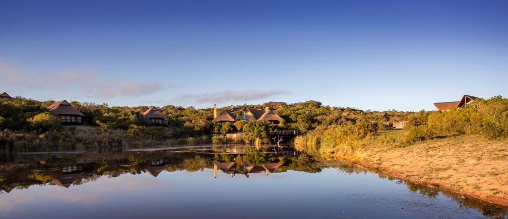 帕特森Lalibela Game Reserve - Kichaka Lodge的享有河流美景,拥有房屋的背景