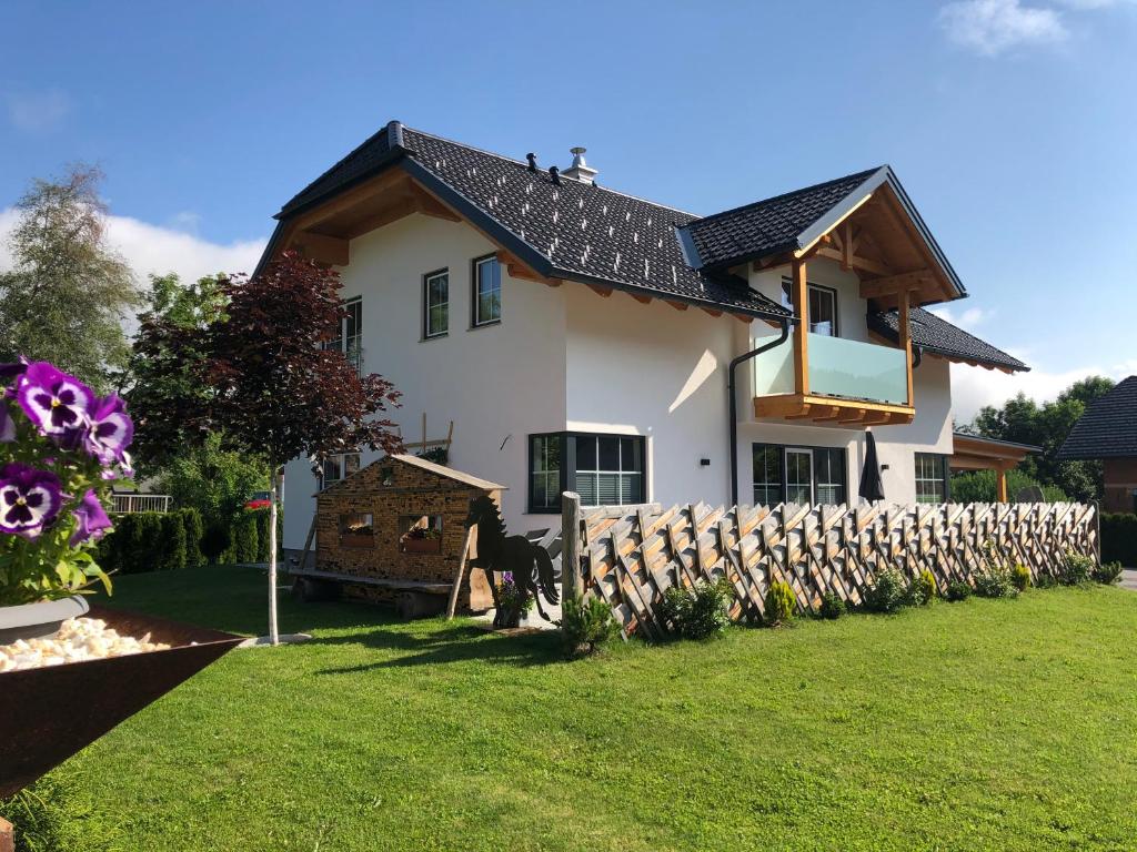 隆高地区圣玛格丽滕Ferienhaus Wind的庭院中带木栅栏的房子