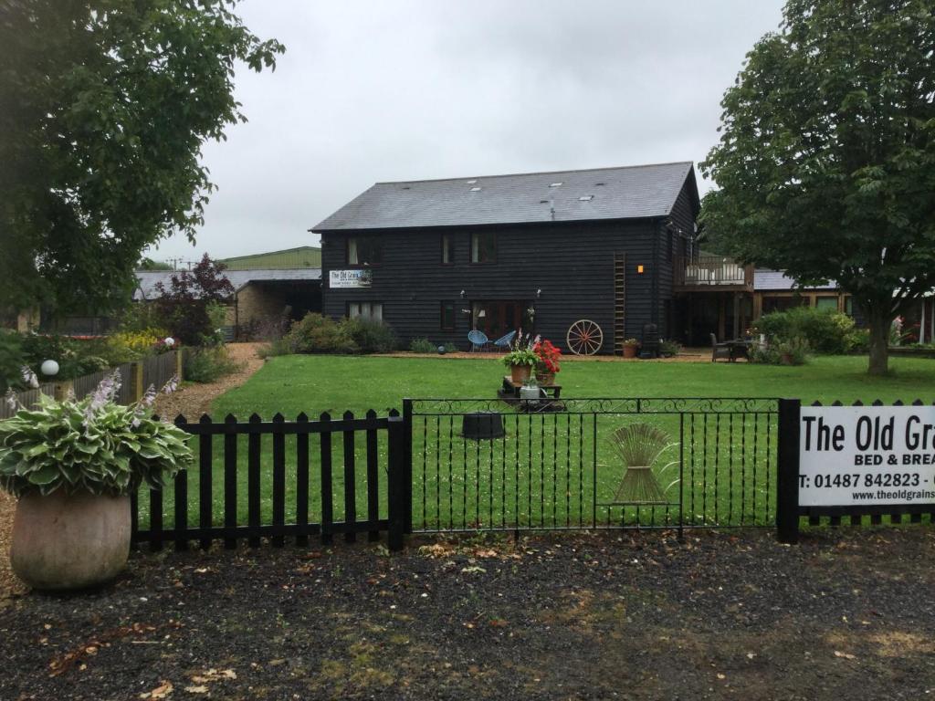 Pidley老粮仓住宿加早餐旅馆的房屋前有标志的黑色围栏