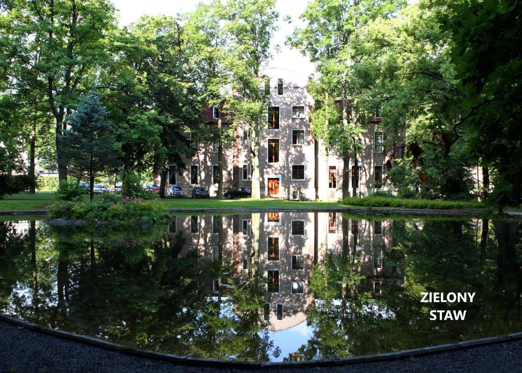 杜什尼基-兹德鲁伊穆索酒店的一座老建筑,在池塘里反射