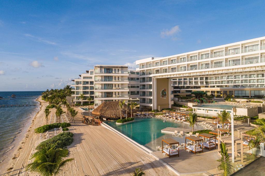 莫雷洛斯港Sensira Resort & Spa Riviera Maya All Inclusive的毗邻大海的带游泳池的酒店