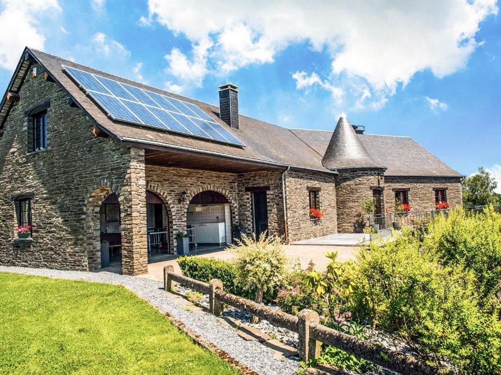比埃夫勒Appealing villa in Bi vre with garden的屋顶上设有太阳能电池板的石头房子