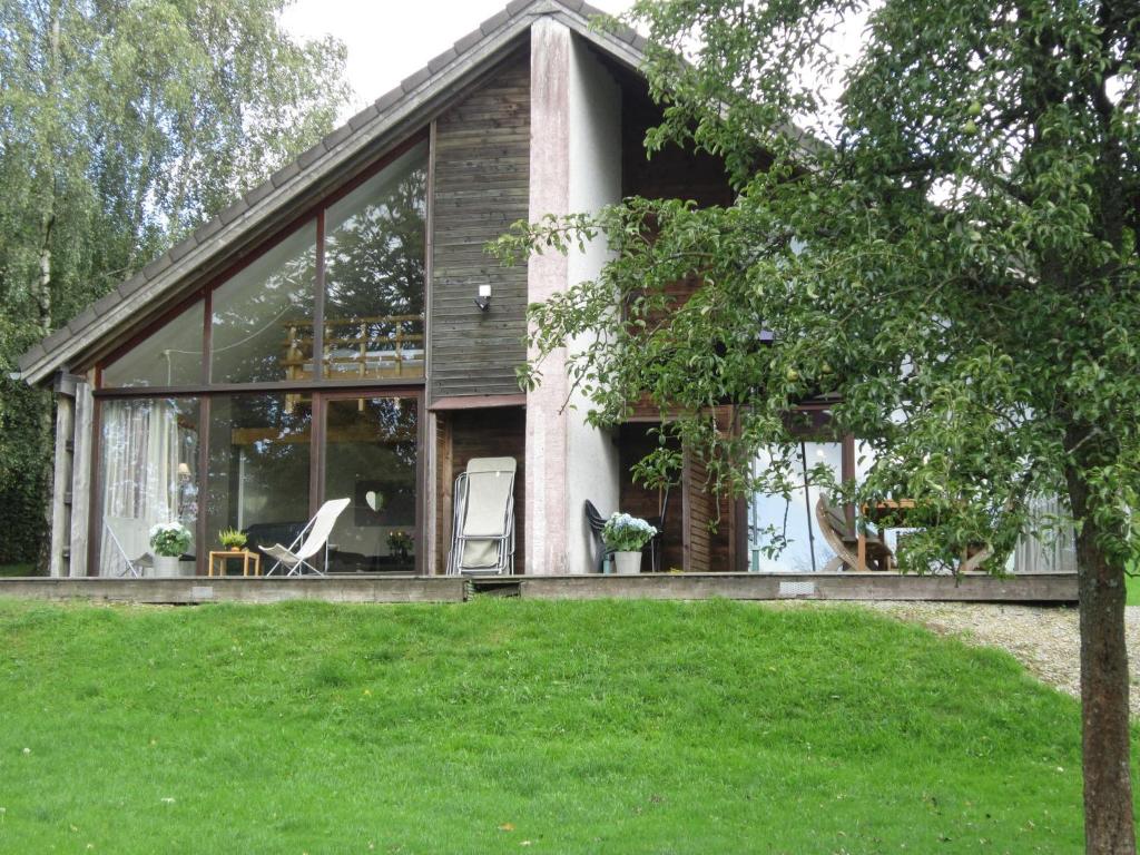 马尔梅迪赛格尼沃木屋的一座带玻璃窗和草坪的房子