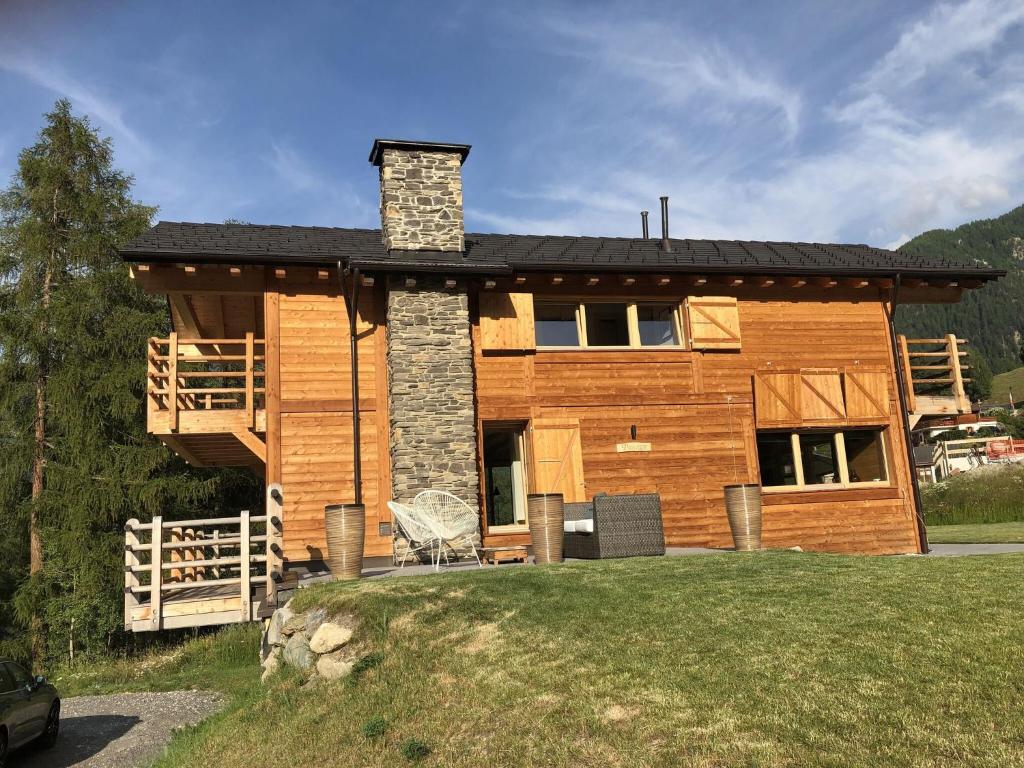 拉茨欧马兹Top chalet with unobstructed view inthe ski resort的一个带门廊和烟 ⁇ 的原木度假屋