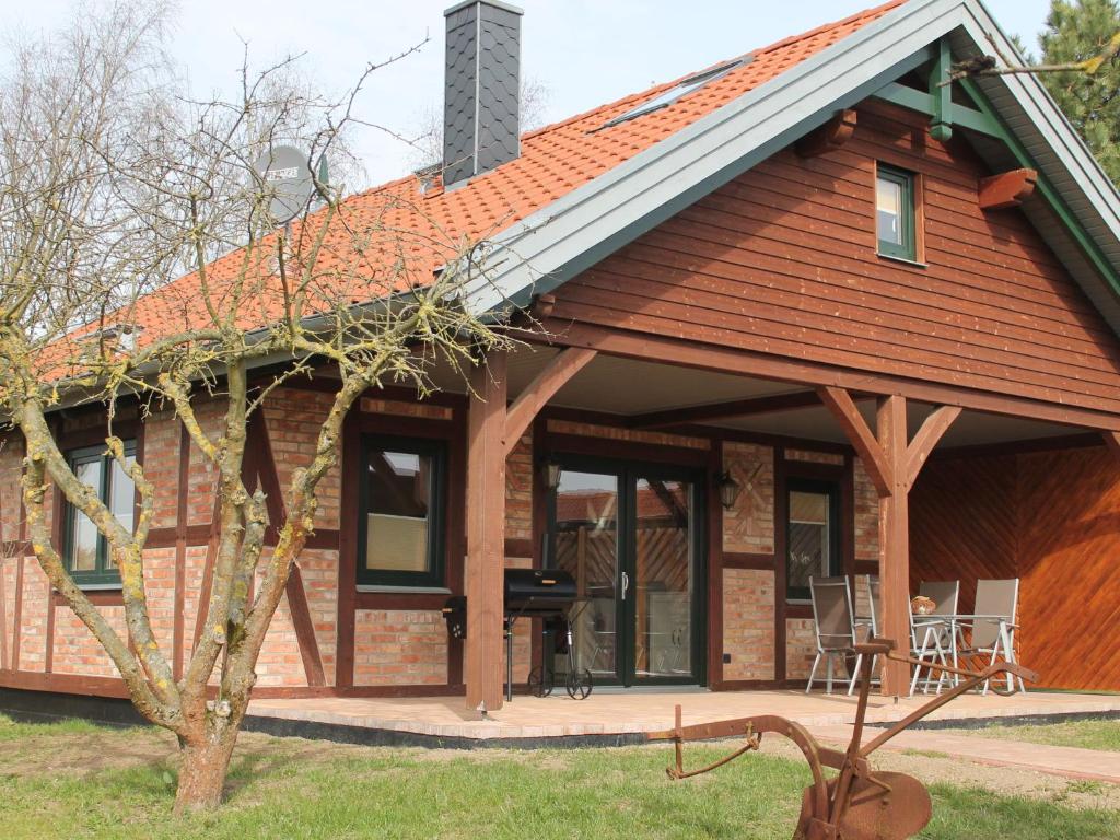 克勒珀林Comfy Farmhouse in Brusow with Garden的一座带露台的红色屋顶房子