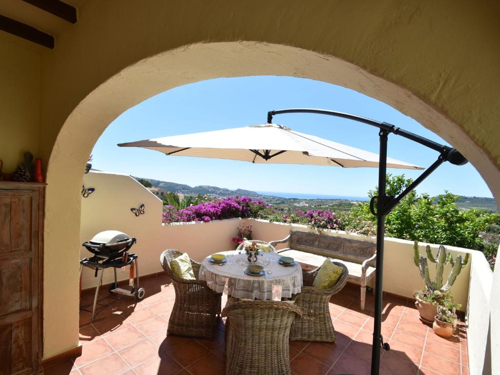 莫莱拉Belvilla by OYO Casa Kola的一个带桌子和遮阳伞的庭院