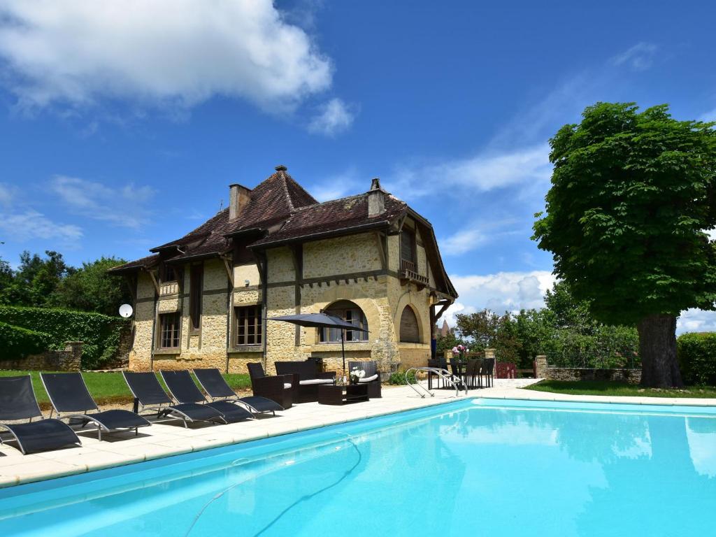 贝尔韦Sumptuous Mansion in Belves with Pool的大楼前带游泳池的房子