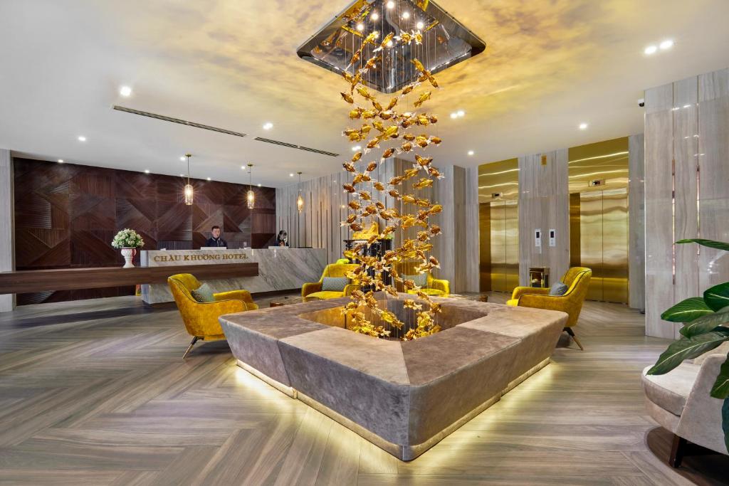 龙川市CHAU KHUONG HOTEL的大堂设有大桌子和黄色椅子
