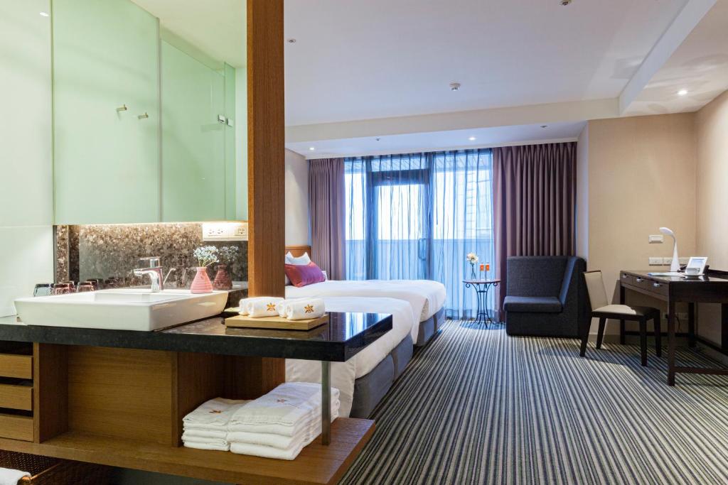 台北太平洋商旅的酒店客房设有床、水槽和浴室